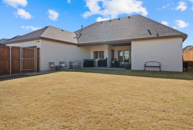 back of property with a yard and a patio area