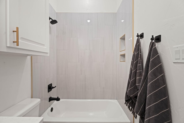 bathroom with toilet and tiled shower / bath combo