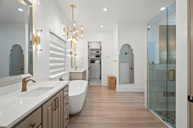 bathroom featuring vanity, hardwood / wood-style floors, independent shower and bath, and a chandelier