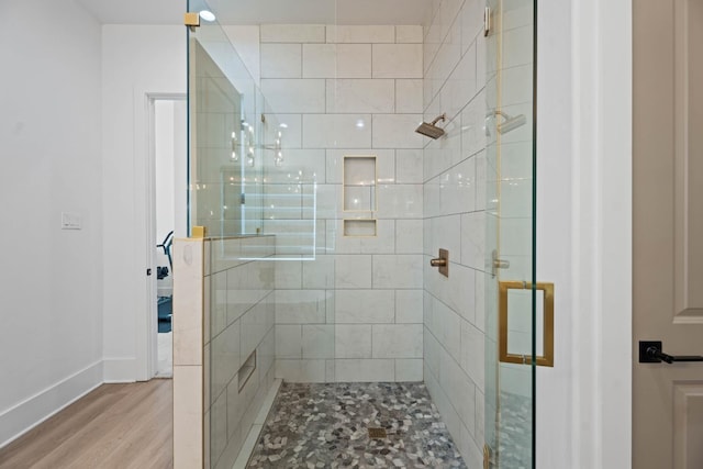 bathroom featuring a shower with shower door and wood-type flooring