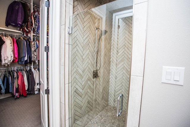 full bathroom featuring a stall shower and a walk in closet