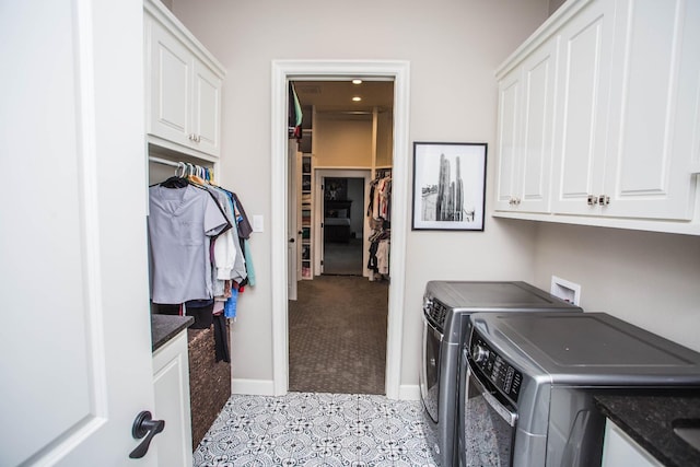 laundry room featuring washing machine and clothes dryer, cabinet space, and baseboards