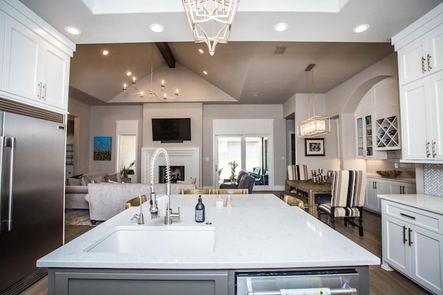 kitchen featuring a center island with sink, white cabinetry, stainless steel appliances, and open floor plan