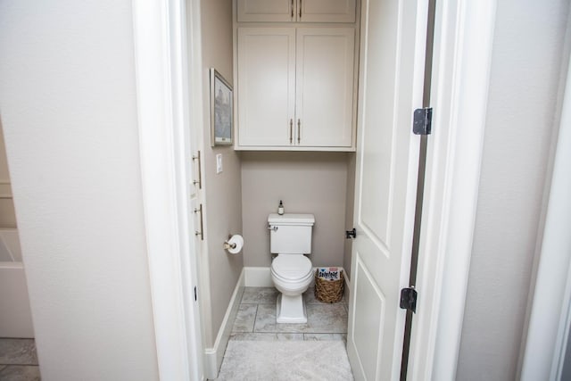 bathroom with toilet, tile patterned flooring, and baseboards