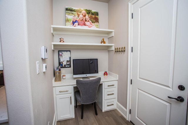 office area featuring dark wood-type flooring and built in desk