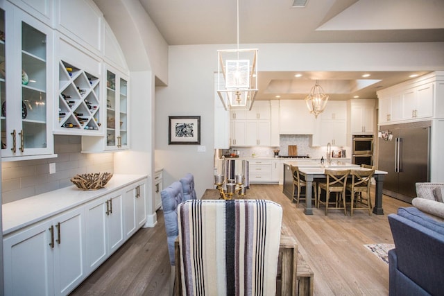 dining area featuring recessed lighting, visible vents, a tray ceiling, and wood finished floors