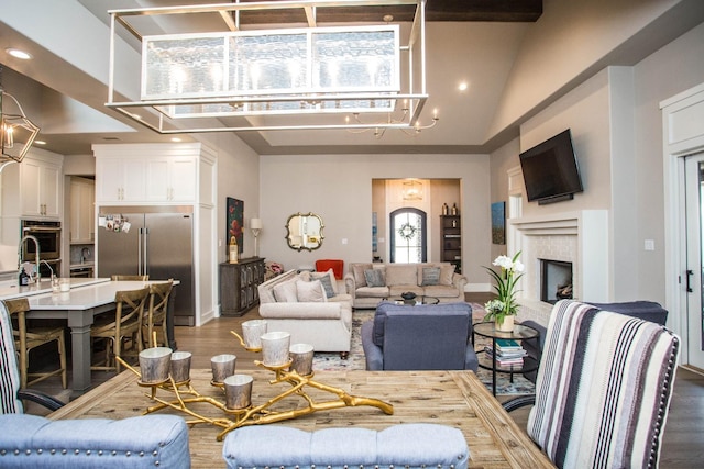 living room featuring high vaulted ceiling, a brick fireplace, dark wood-style flooring, and recessed lighting