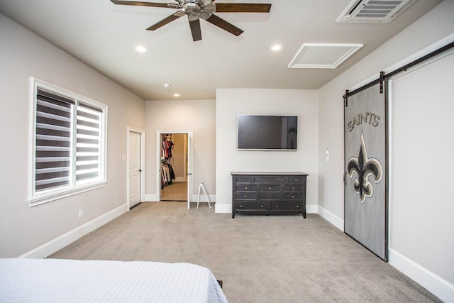 bedroom with recessed lighting, visible vents, a barn door, light carpet, and baseboards