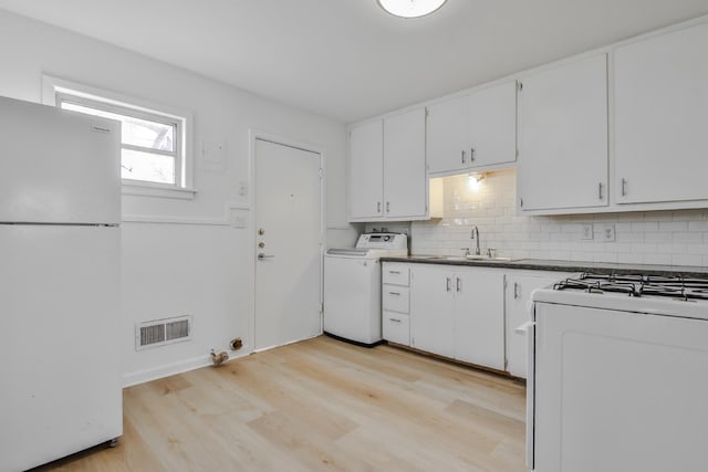 kitchen with white appliances, washer / clothes dryer, sink, and white cabinets