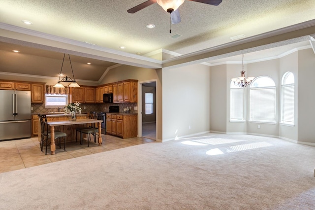 kitchen featuring vaulted ceiling, a kitchen breakfast bar, a kitchen island, light colored carpet, and stainless steel appliances