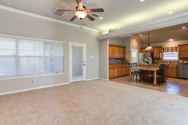 interior space with a center island, light carpet, appliances with stainless steel finishes, a kitchen breakfast bar, and pendant lighting