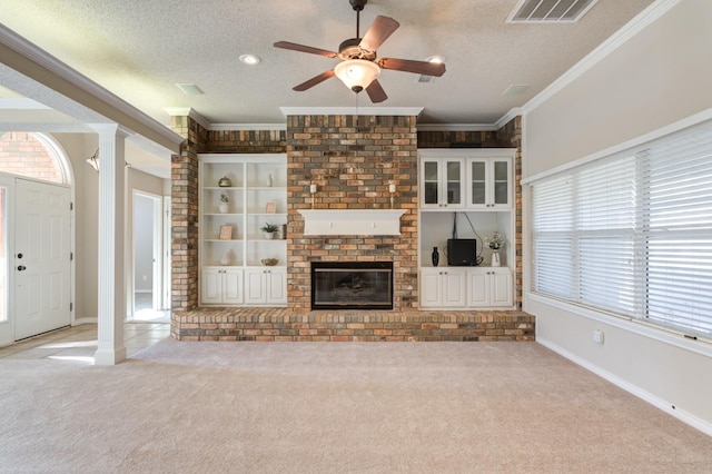 unfurnished living room with light carpet, crown molding, decorative columns, and a textured ceiling