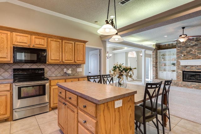 kitchen featuring pendant lighting, electric range, a center island, a textured ceiling, and light tile patterned flooring