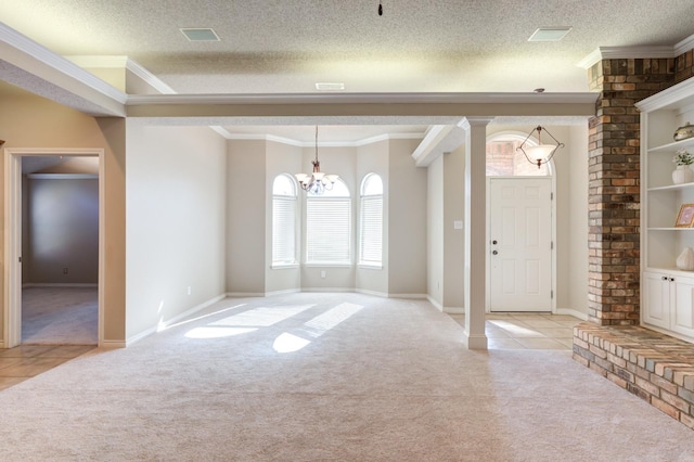 carpeted entryway featuring crown molding, an inviting chandelier, and a textured ceiling