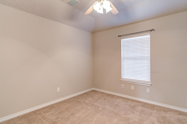 unfurnished room featuring plenty of natural light, light colored carpet, and ceiling fan