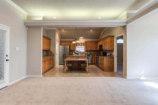 kitchen featuring stainless steel appliances, an island with sink, light colored carpet, and decorative backsplash