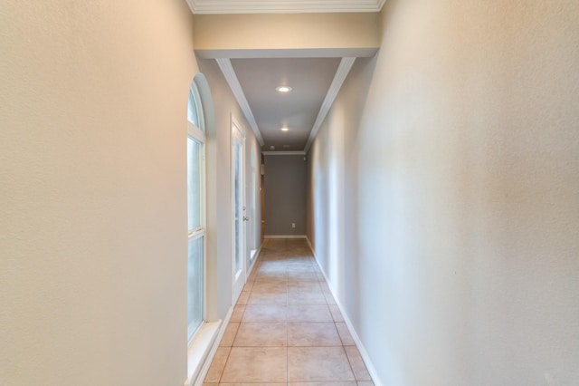 corridor featuring ornamental molding and light tile patterned floors