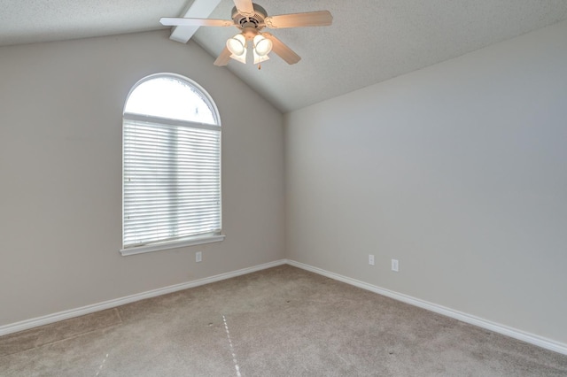 unfurnished room featuring light colored carpet, a wealth of natural light, lofted ceiling with beams, and ceiling fan