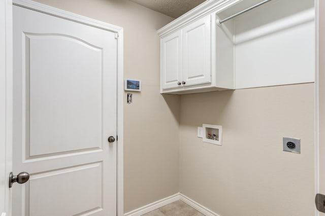 laundry room featuring electric dryer hookup, hookup for a washing machine, cabinets, a textured ceiling, and light tile patterned flooring