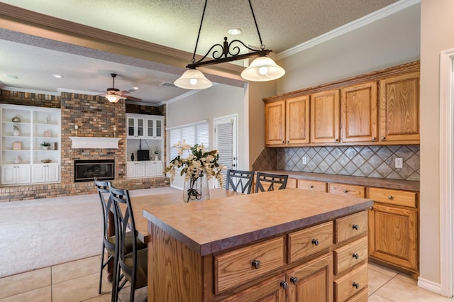 kitchen featuring a kitchen bar, decorative backsplash, a center island, light tile patterned floors, and a textured ceiling