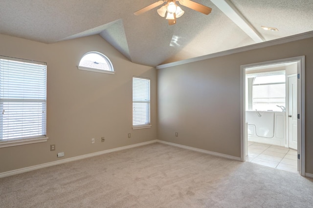 spare room with ceiling fan, light colored carpet, lofted ceiling, and a textured ceiling