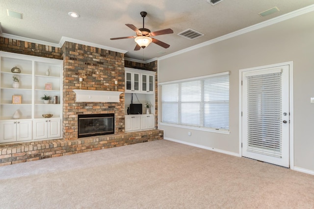 unfurnished living room featuring ceiling fan, carpet floors, a fireplace, ornamental molding, and a textured ceiling