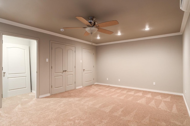 unfurnished bedroom with ceiling fan, light colored carpet, ornamental molding, and multiple closets