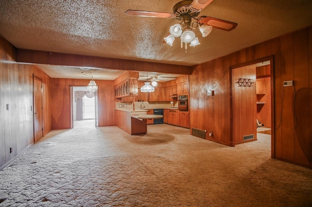 kitchen featuring dishwasher, hanging light fixtures, wall oven, light carpet, and a textured ceiling