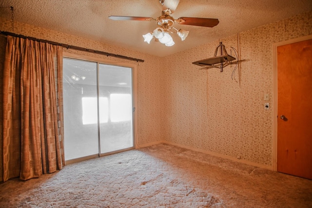 carpeted spare room with ceiling fan and a textured ceiling
