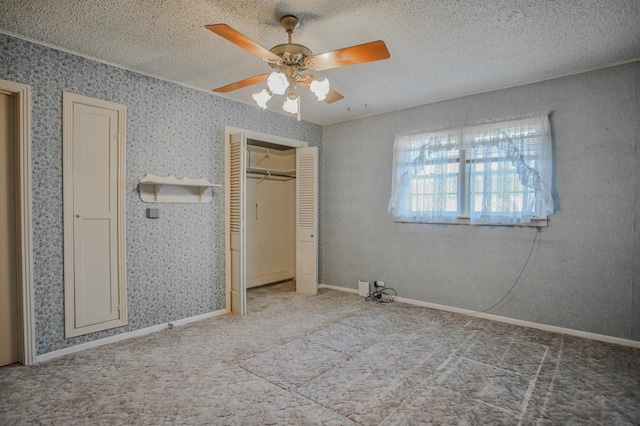 unfurnished bedroom with ceiling fan, carpet floors, and a textured ceiling