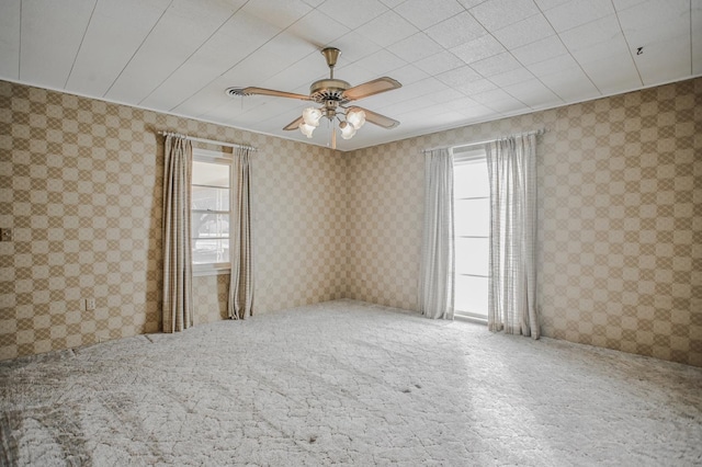 spare room featuring ceiling fan and a healthy amount of sunlight