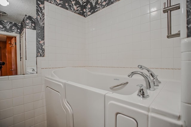 bathroom featuring a washtub and a textured ceiling