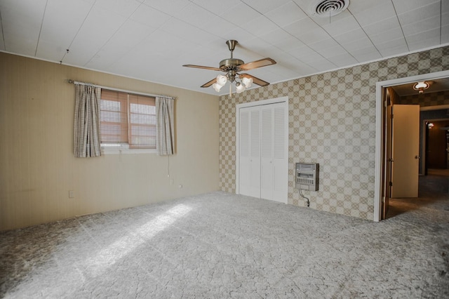 unfurnished bedroom featuring ceiling fan, a closet, carpet, and heating unit