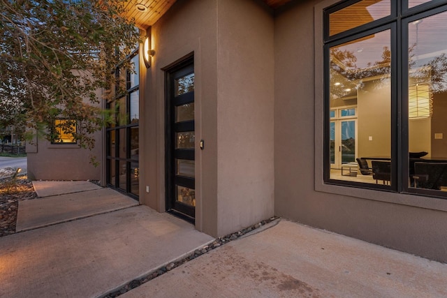 view of exterior entry with a patio area