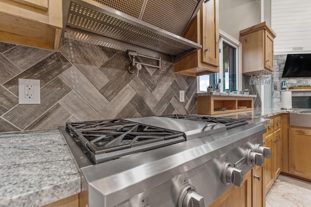 kitchen featuring backsplash, wall chimney exhaust hood, and stove