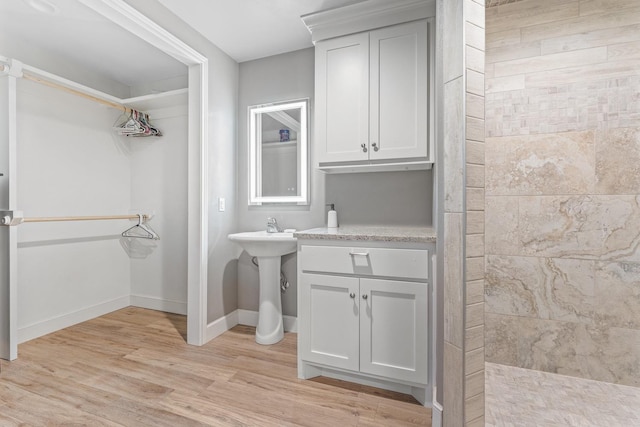 bathroom featuring hardwood / wood-style flooring and tiled shower