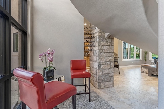 living area featuring vaulted ceiling and a textured ceiling