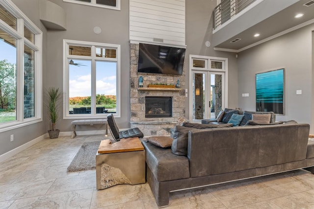 living room featuring ornamental molding, a fireplace, and a high ceiling