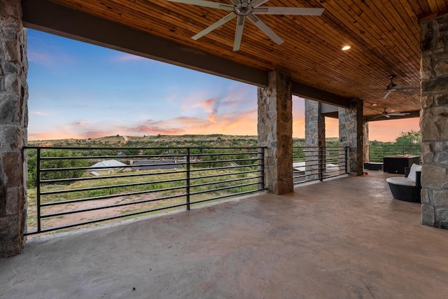 patio terrace at dusk featuring ceiling fan