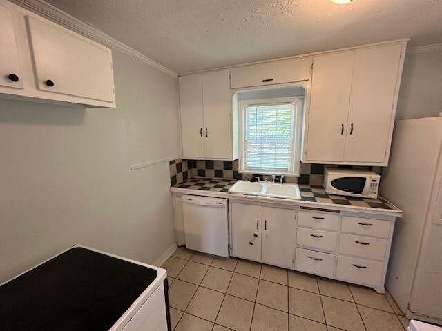 kitchen with white cabinetry, white appliances, and sink