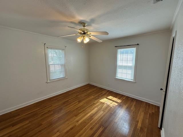 empty room with ceiling fan, ornamental molding, dark hardwood / wood-style floors, and a textured ceiling