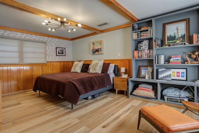 bedroom featuring ornamental molding, a notable chandelier, and light wood-type flooring