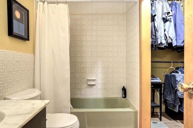 full bathroom with tile walls, vanity, shower / bath combo, and toilet