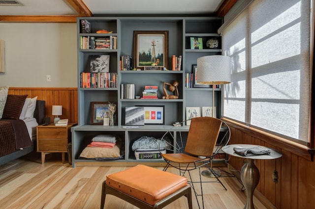 living area with hardwood / wood-style flooring, plenty of natural light, and wood walls