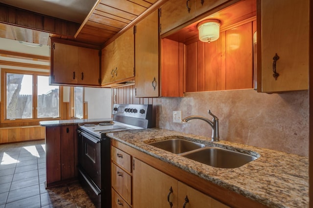 kitchen with sink, backsplash, dark tile patterned floors, electric range, and light stone countertops