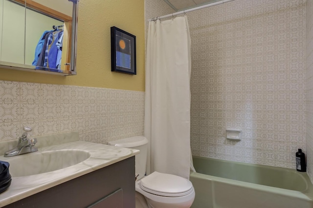 full bathroom with tile walls, vanity, toilet, and shower / bath combo with shower curtain