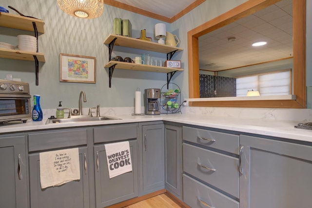 kitchen with gray cabinetry, sink, and light hardwood / wood-style flooring