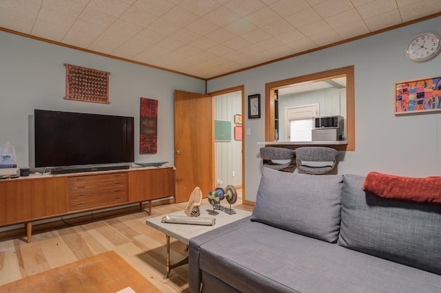 living room with crown molding and light hardwood / wood-style flooring