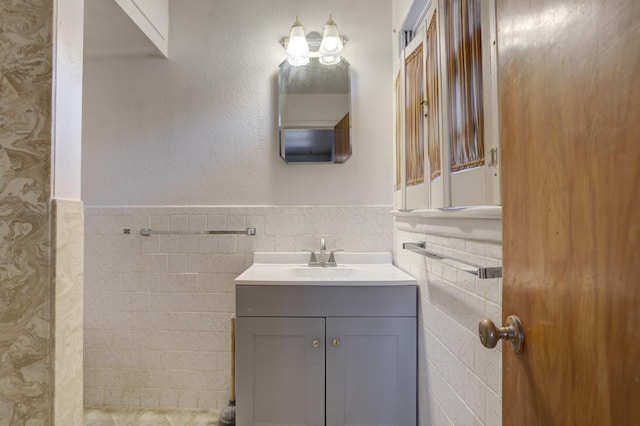 bathroom featuring vanity and tile walls