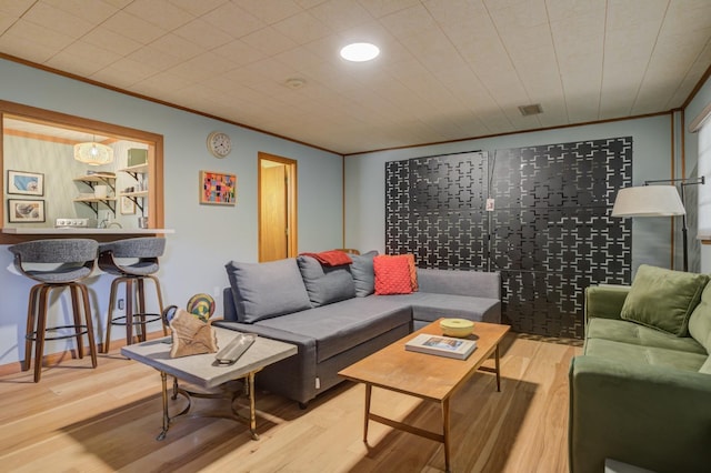 living room with hardwood / wood-style floors and crown molding